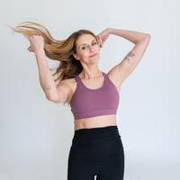 Woman wearing purple adjustable strappy back sports bra.