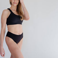 Woman wearing black super absorbent leakproof underwear from Joyleta, a maternity store in Canada.