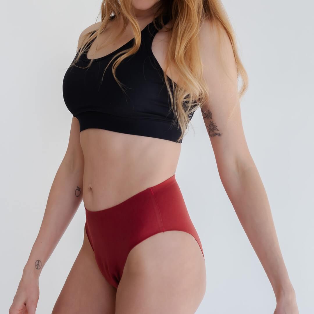 Woman wearing red super absorbent leakproof underwear from Joyleta, a maternity activewear store in Canada.
