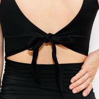 Woman showing cute back of black maternity bathing suit top.
