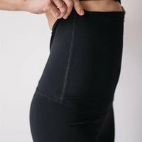Woman wearing black maternity leggings and nursing sports bra.