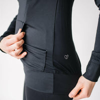 Woman showing kangaroo pocket of black nursing hoodie from Joyleta (maternity store in Canada).