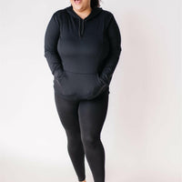 Woman smiling, wearing black maternity leggings and black nursing hoodie from Joyleta maternity store Canada.