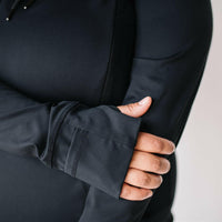 Woman showing thumb holes of black nursing hoodie from Joyleta Canada.