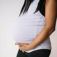 Woman wearing long maternity tank top in lavender.