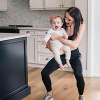 Woman wearing black maternity leggings and nursing sports bra.