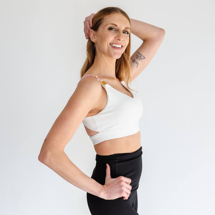 Back view of woman wearing purple strappy maternity and nursing sports bra from Joyleta.