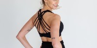 Woman showing strappy-back of black nursing sports bra from Joyleta Canada.