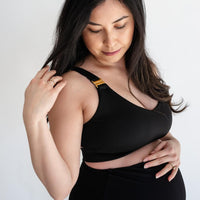 Pregnant woman wearing black nursing sports bra and black maternity leggings from Joyleta Canada.