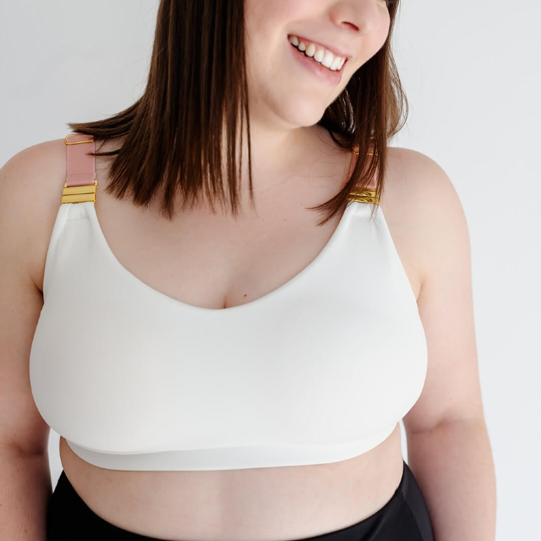 Woman showing front of white nursing sports bra from Joyleta maternity activewear Canada.