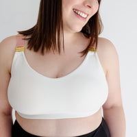 Woman showing front of white nursing sports bra from Joyleta maternity activewear Canada.