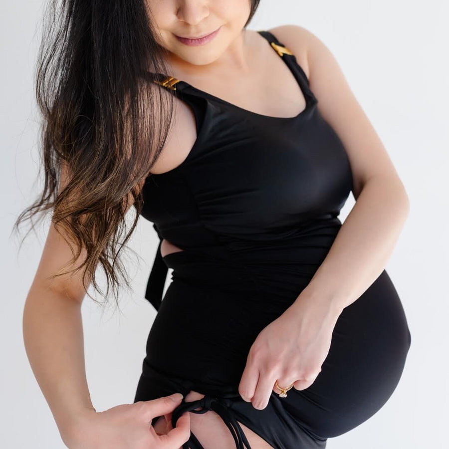 Woman showing side of black maternity swimsuit bottoms from Canadian maternity activewear company, Joyleta.