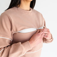 Woman showing dual zipper openings on warm zipper breastfeeding sweatshirt in PinkTaupe from maternity store in Canada.