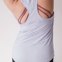 Woman showing racerback of long maternity tank top in lavender.
