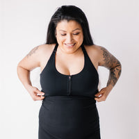 Woman wearing black front-zip nursing sports bra.