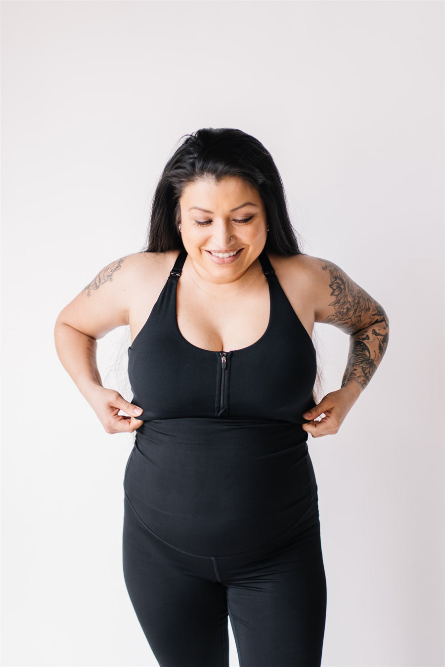 Woman wearing black front-zip nursing sports bra.