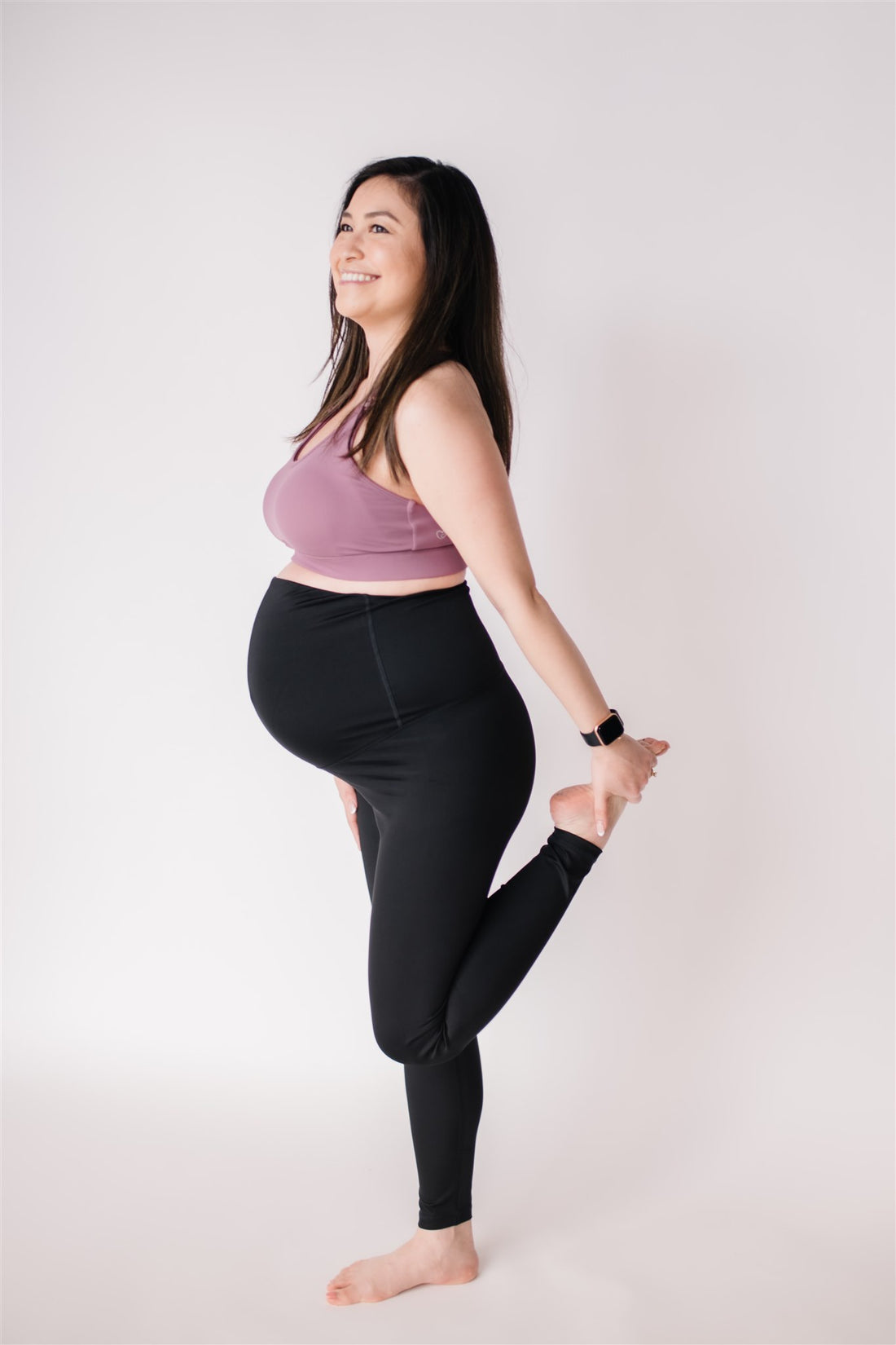 Woman wearing black maternity leggings and nursing sports bra.