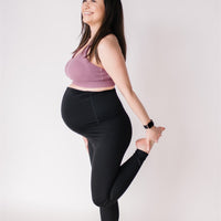 Woman wearing black maternity leggings and nursing sports bra.