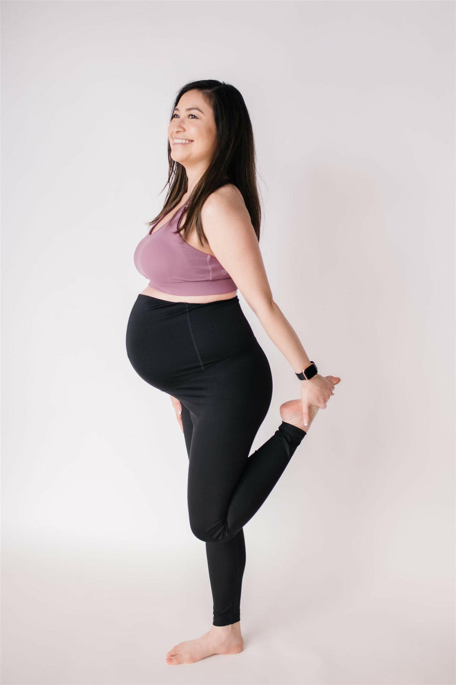 Woman wearing black maternity leggings and nursing sports bra.