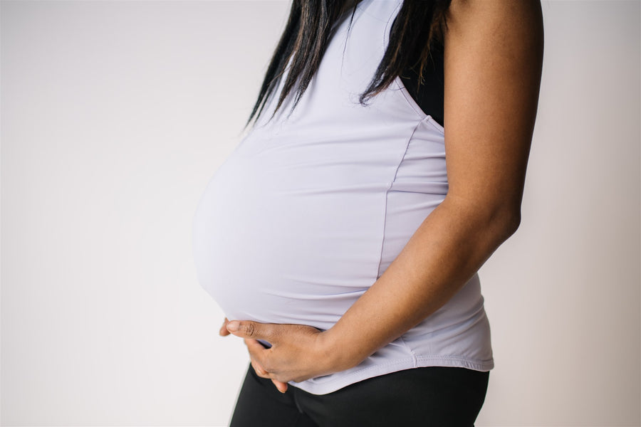 Woman wearing long maternity tank top in lavender.