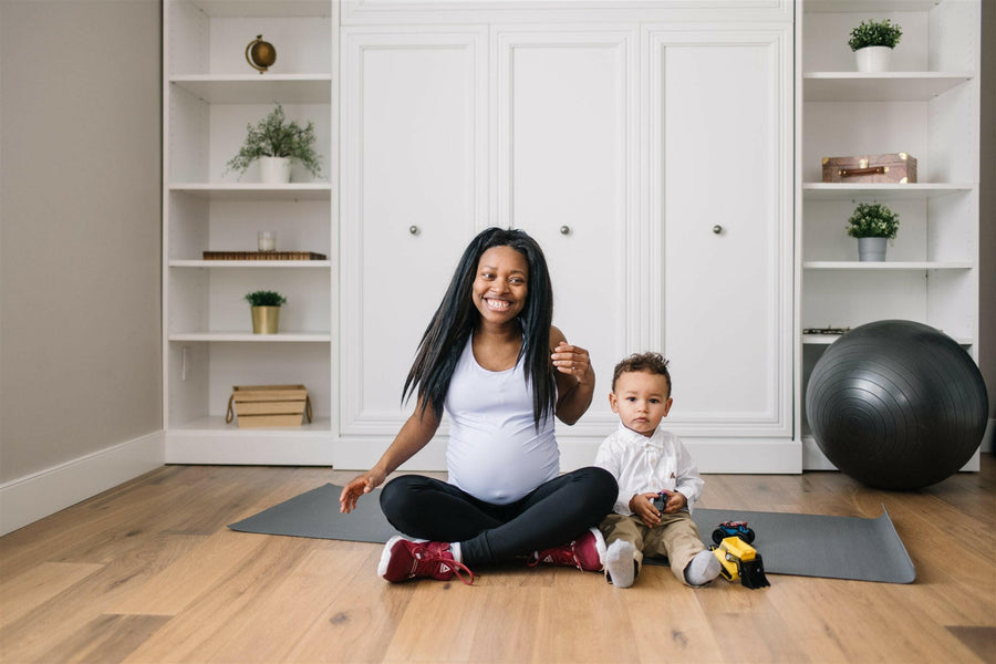 Woman wearing long maternity tank top in lavender.