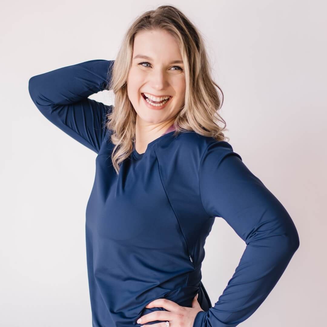Woman wearing long maternity and nursing long sleeve top with invisible nursing zippers, in midnight blue.